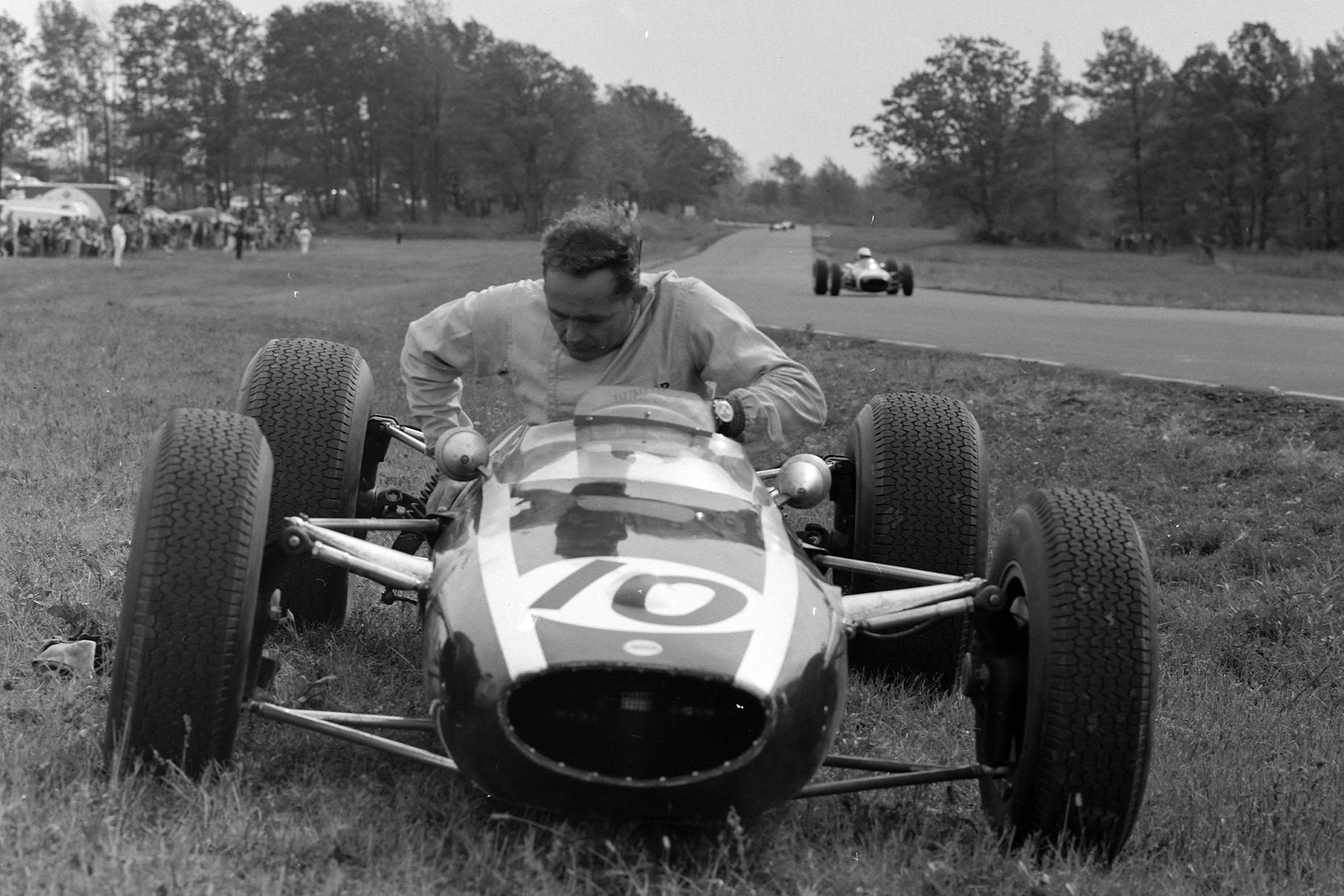 Phil Hill climbs from his Cooper after retiring from on lap 5