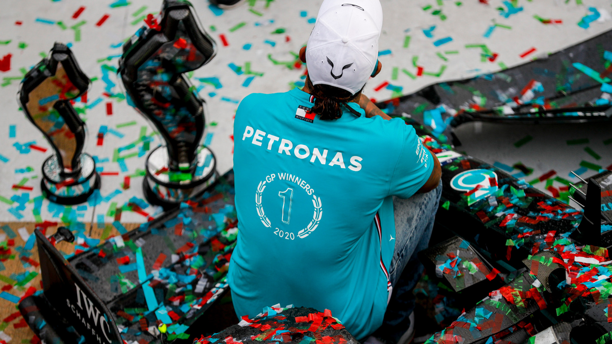 Lewis Hamilton sits on his Mercedes covered in ticker tape after clinching the 2020 F1 constructors championship at Imola